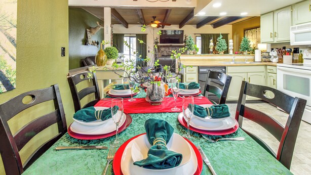 A dining room with a green tablecloth, red napkins, and a chandelier. - Nat'l Forest Retreat at 'the Nest at Pinetop' (Pinetop)