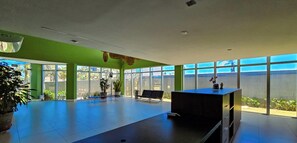 Eine großzügige Lobby mit großen Fenstern, einem Empfangsschalter und mehreren Sitzbereichen.