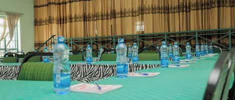 A conference room with tables set up for a meeting, equipped with water bottles and name cards.