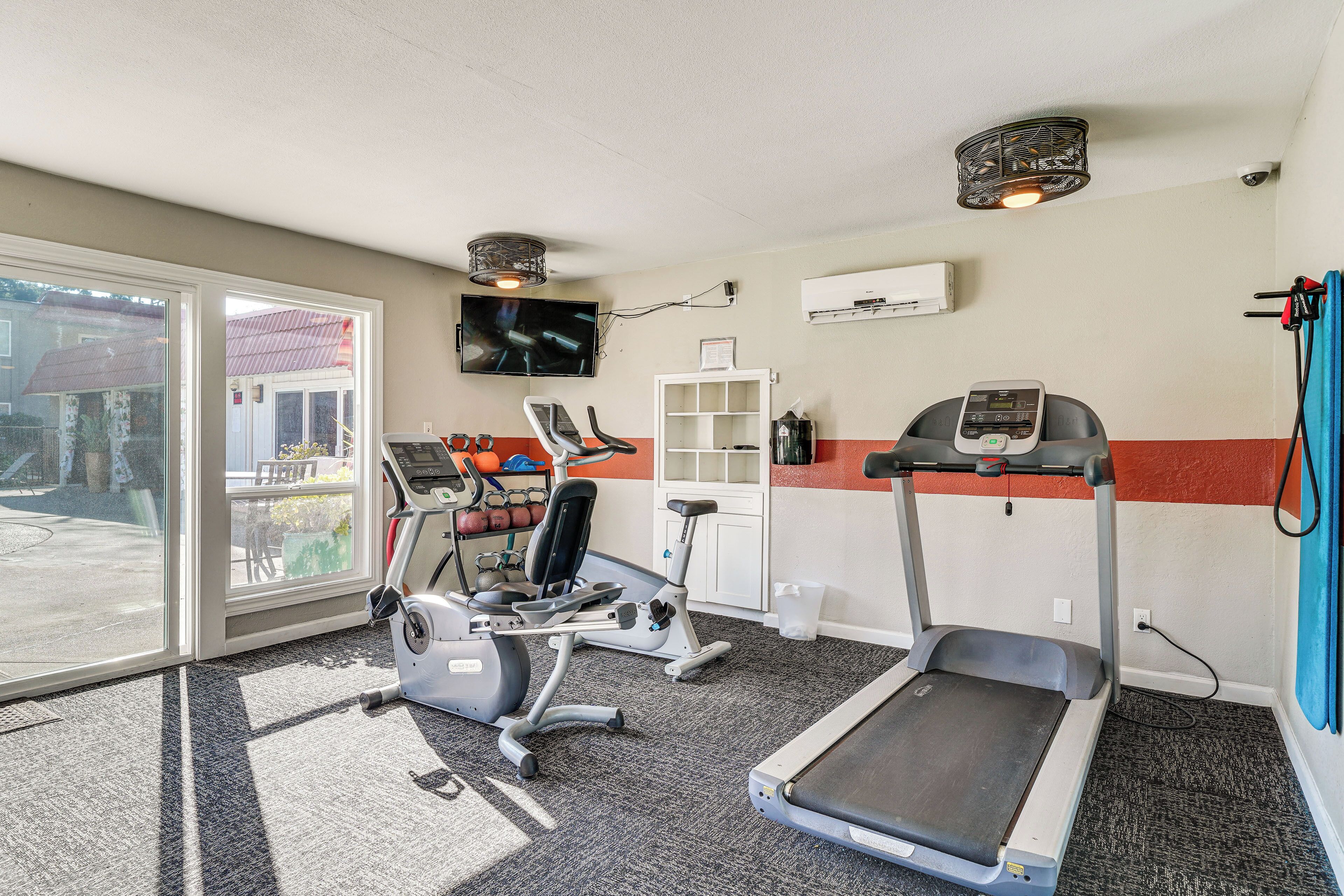 A gym with treadmills, stationary bikes, and a weight bench.