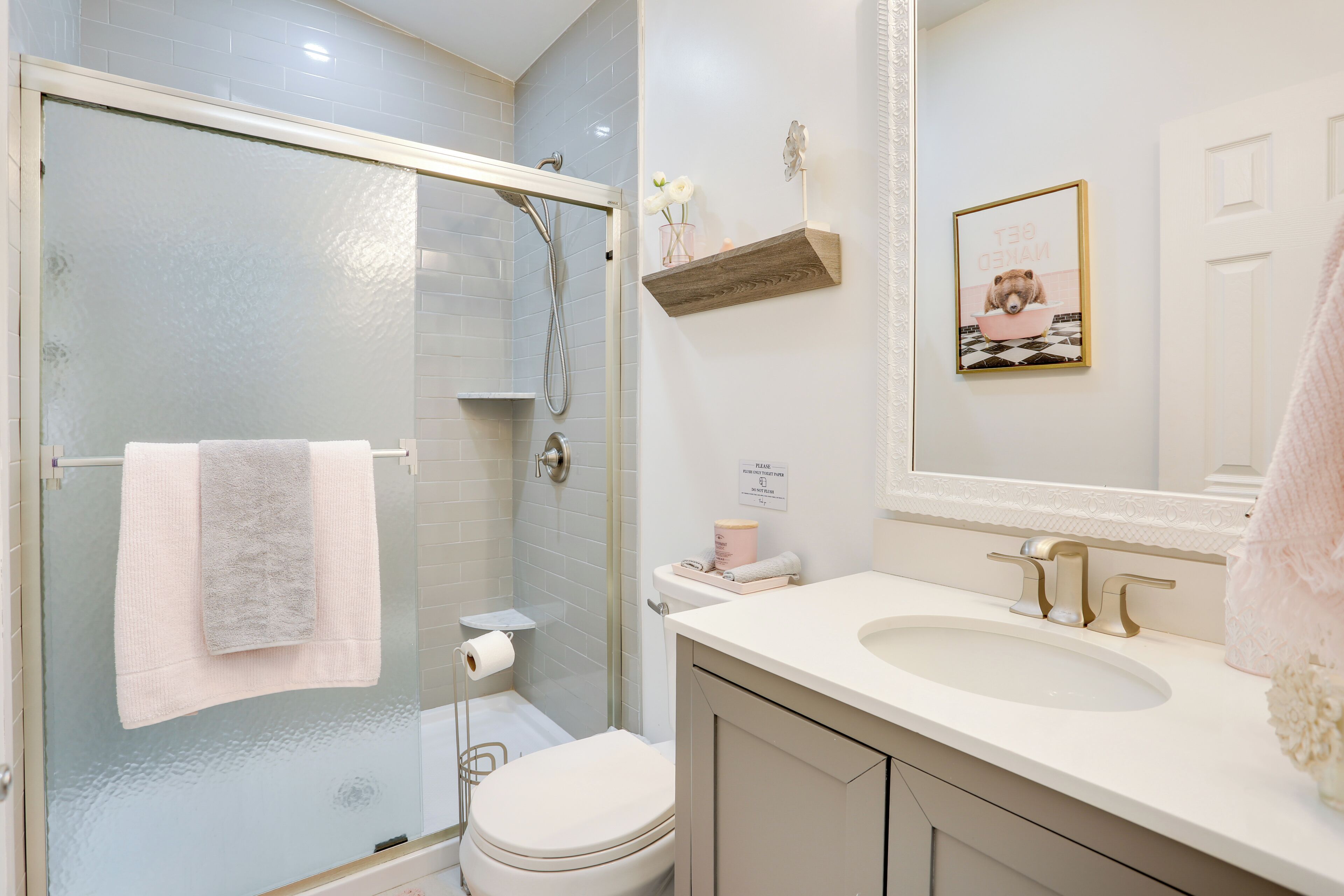 Un baño con ducha de vidrio, inodoro, lavabo y espejo.