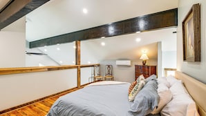 A bedroom with a bed, wooden floor, and a staircase. - Peaceful Farmhouse Retreat 6 Mi to Virginia Tech! (Blacksburg)