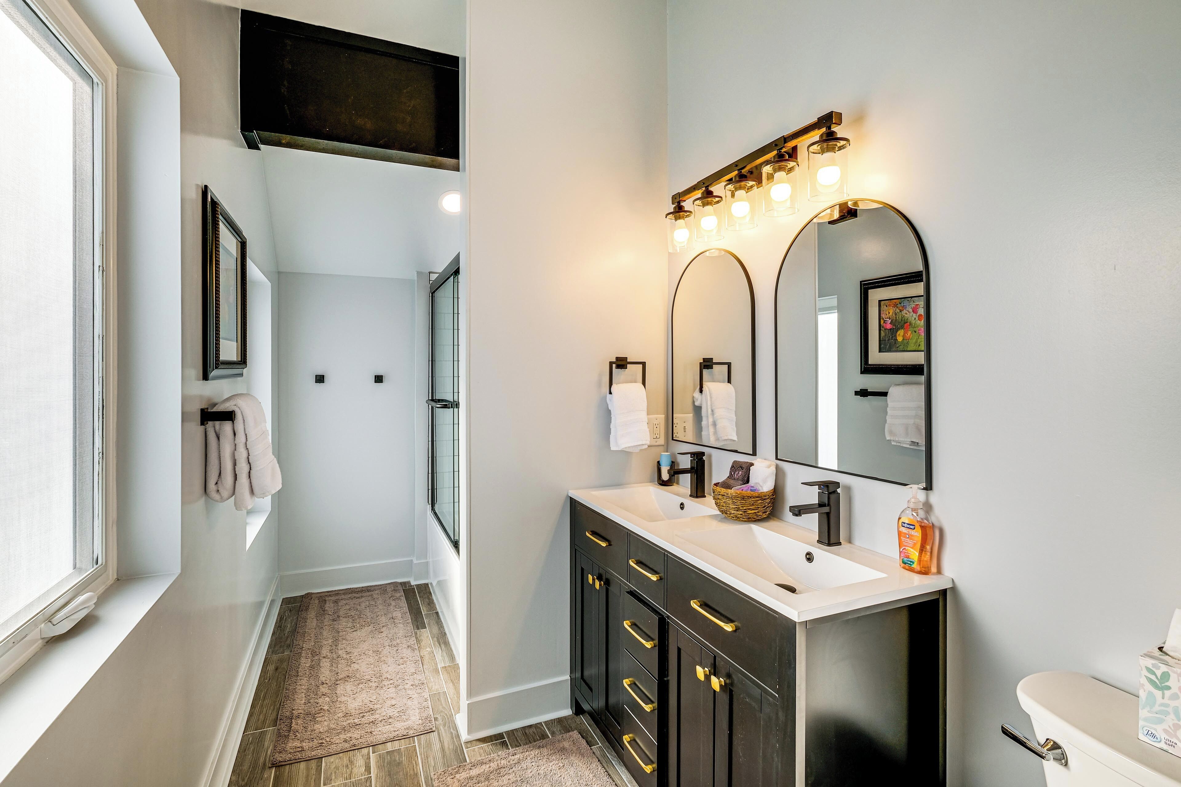 A modern bathroom with a vanity, sink, and mirror.