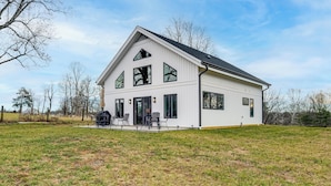 A modern two-story house with a large front porch, a dining area with outdoor seating, and a spacious backyard. - Peaceful Farmhouse Retreat 6 Mi to Virginia Tech! (Blacksburg)