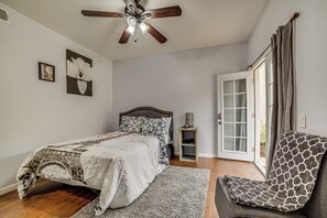 A bedroom with a bed, a chair, a nightstand, a ceiling fan, and a door leading to an outdoor area. - Sip, Hike & Explore: Quiet Socal Studio w/ Patio! (Winchester)