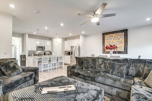 A modern living room with a sofa, ottoman, and a dining area in the background. - Work & Play Near Old Hickory Lake! Home w/ Patio (Gallatin)