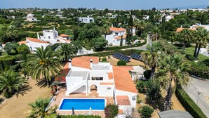 A white villa with a swimming pool, surrounded by palm trees and a garden. - Casa Rouxinol in Carvoeiro (Lagoa)