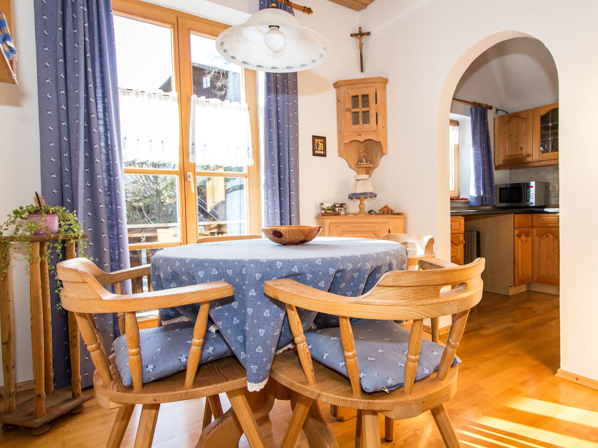 Ein Essbereich mit einem runden Tisch, vier Holzstühlen und einer blauen Tischdecke.