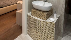 Un bany modern amb un mirall gran, un lavabo i una dutxa.