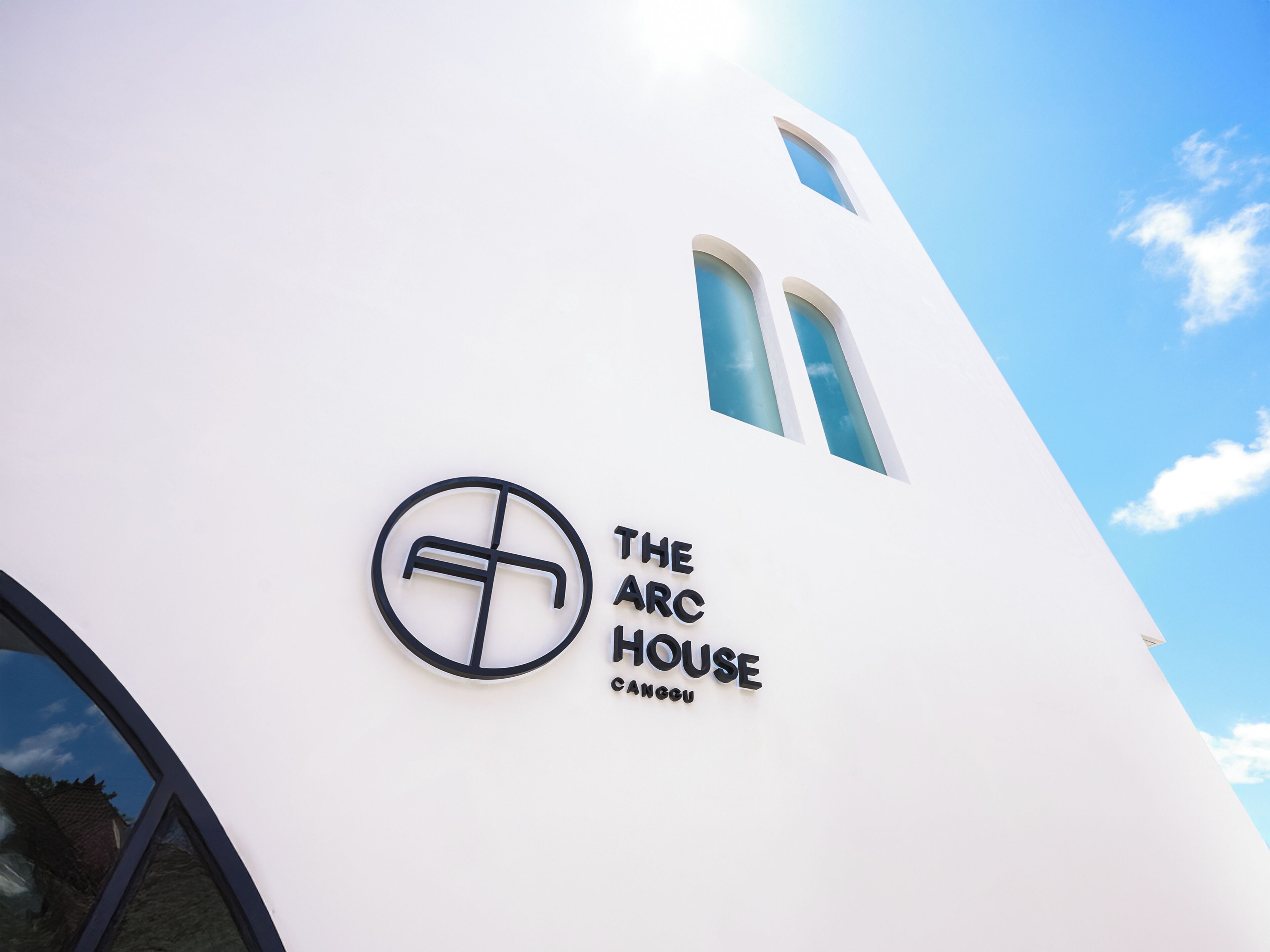 Rakennuksessa on valkoinen julkisivu, logo ja teksti: »THE ARC HOUSE CANGCU».