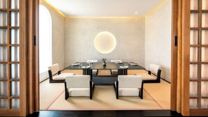 Une salle de conférence équipée d’une table ronde, de chaises et d’un luminaire central.
