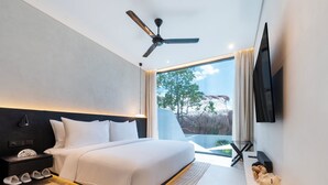 Une chambre d’hôtel moderne dotée d’un grand lit, d’un ventilateur de plafond, d’un téléviseur à écran plat et offrant une vue sur l’extérieur.