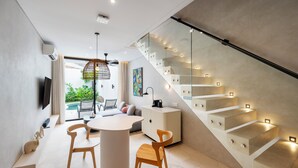 Un intérieur moderne comprenant un escalier, un coin repas et un espace de vie avec vue.