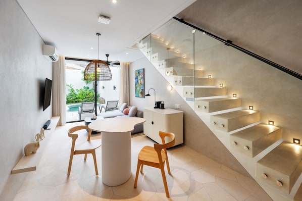 A modern interior with a staircase, a dining area, and a living space with a view. - The Arc House Canggu (Canggu)
