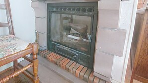 Una chimenea con un marco de ladrillo y un repisa de madera.
