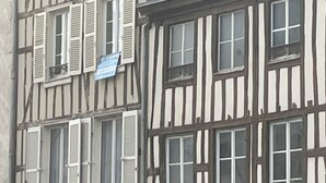 A traditional half-timbered building with multiple windows and shutters, a satellite dish on the roof, and a visible sign on the ground floor. - Super-central apartment for family or business (Châlons-en-Champagne)