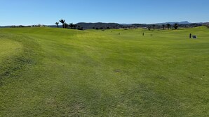 A golf course with a clear sky, green grass, and distant hills. - Casa Montgavina, villa in the heart of Vistabella Golf (Entrenaranjos)