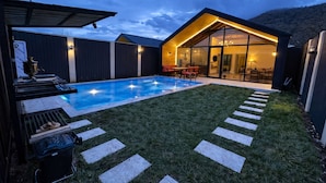 A backyard with a swimming pool, a barbecue area, and a dining area with outdoor seating. - Hg Barn House Gabala (Gabala)