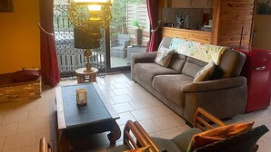 A cozy living room with a sofa, a table, and a hanging light fixture. - Dog-friendly House With Sauna, Bubble Bath (Bouillon)