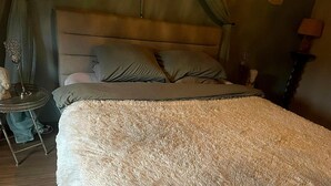 A bed with a fluffy beige blanket, a headboard, and two pillows. - Dog-friendly House With Sauna, Bubble Bath (Bouillon)