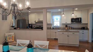 Una cocina moderna con armarios blancos, electrodomésticos de acero inoxidable y una isla central.