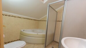 A bathroom with a toilet, a bathtub, and a shower enclosure. - 4-Bedroom Cappadocia Stone Villa in Charming Gökbel with Pool & Scenic Views (Gökbel)