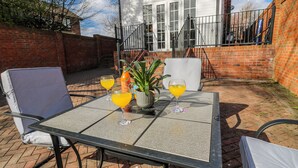 A patio with a table, two chairs, and three drinks. - Middleton Park House (Leeds)