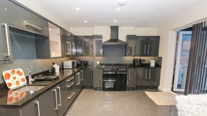 A modern kitchen with stainless steel appliances, a large oven, and a built-in microwave. - Middleton Park House (Leeds)