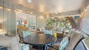 A covered patio area with a round table, chairs, and ceiling fans. - Stunning Sea Pines Retreat with private pool and spa (Hilton Head Island)