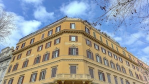Un edificio en esquina con varias ventanas y un balcón.