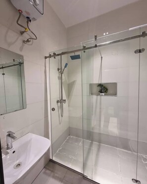 A modern bathroom with a glass-enclosed shower, a white sink, and a mirror. - Cherry Home Solutions (Lekki)