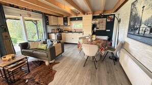 Hyggelig indretning med spiseplads, køkken og siddeområde.