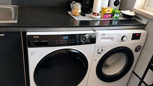 Máquina de lavar com abertura frontal, painel de controle digital e secadora com abertura frontal.