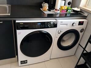 Eine Waschmaschine mit Frontlader, digitalem Display und Bedienfeld sowie ein separater Trockner mit Frontlader.