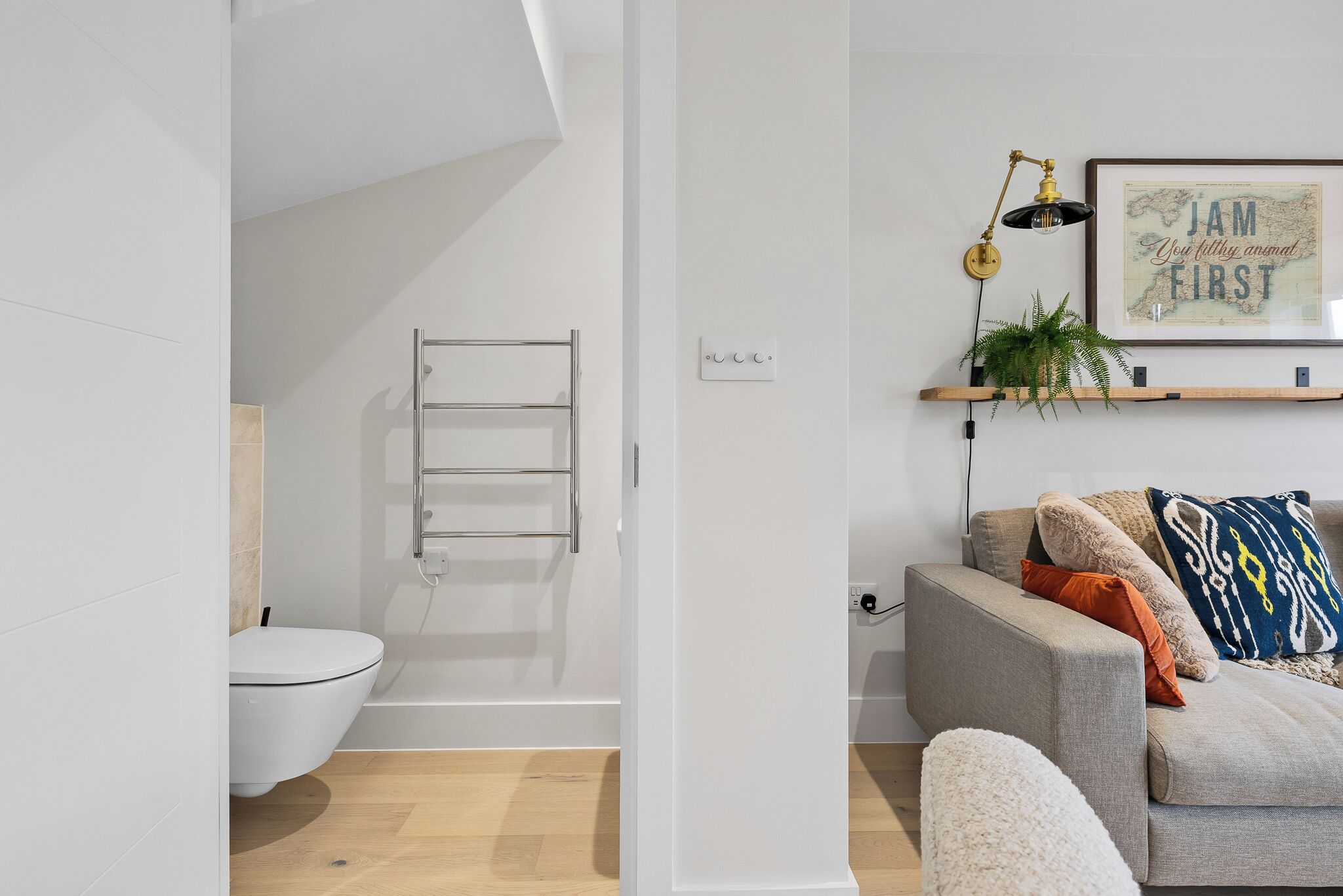 Un baño moderno con inodoro blanco, cabina de ducha de vidrio y un perchero para toallas.