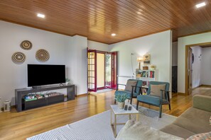 Ein modernes Wohnzimmer mit Fernseher, Couchtisch und Sofa.