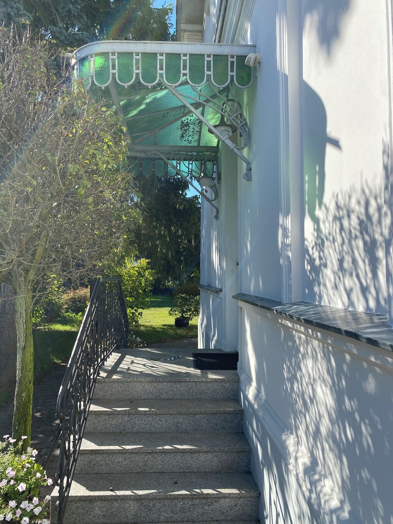 A staircase leading to a building with a green awning and a metal railing.