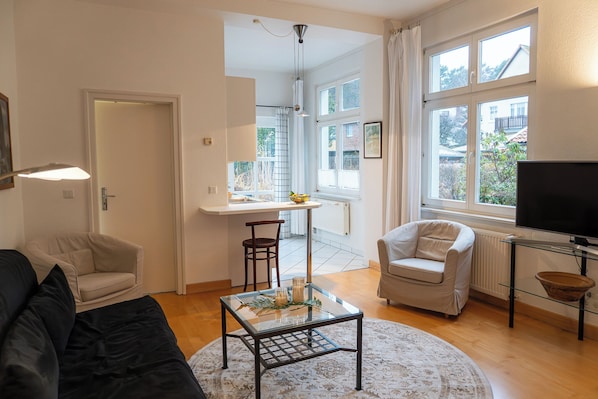 Departamento Deluxe, vista al jardín | Área de sala de estar | Televisión