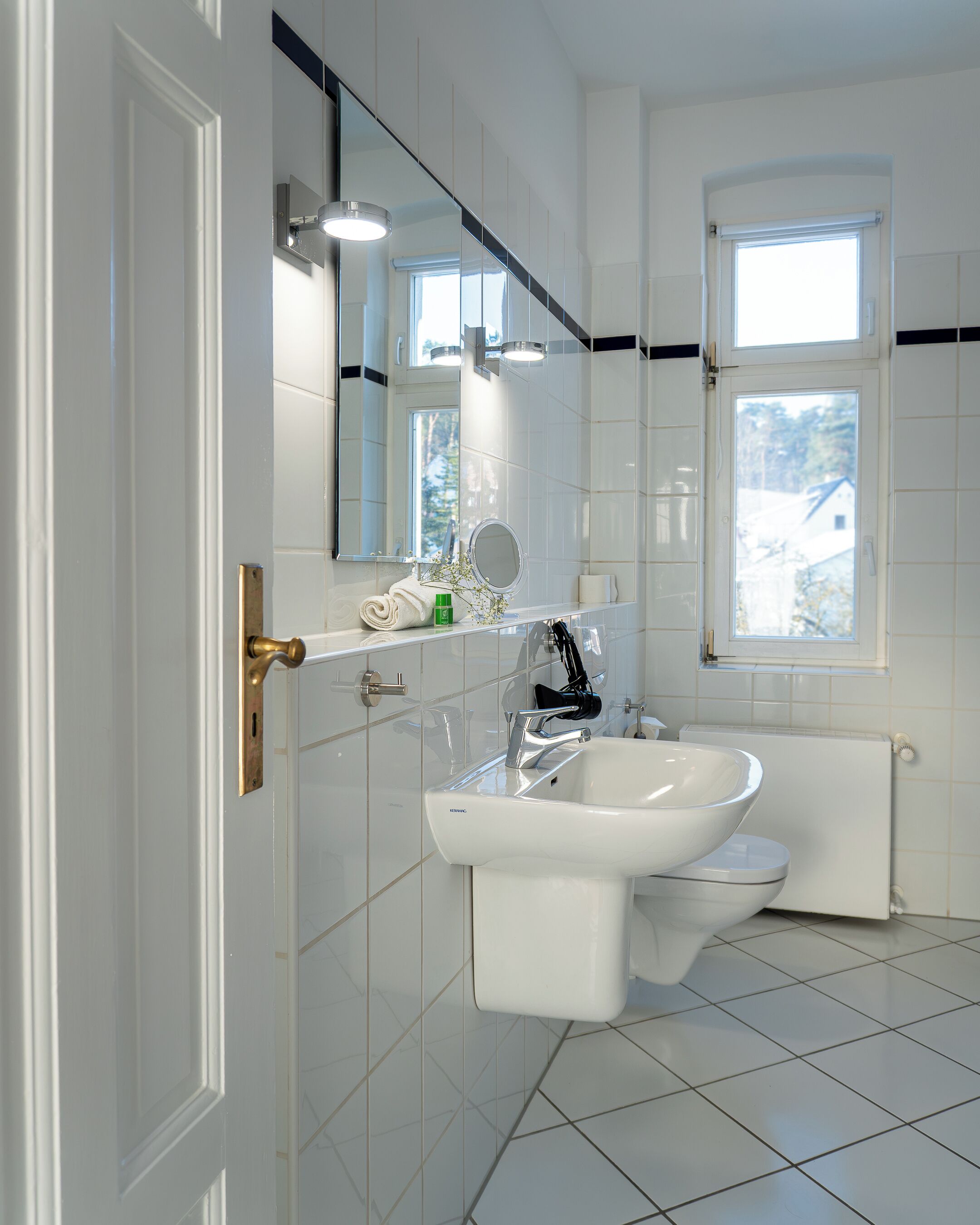 Ein modernes Badezimmer mit Waschbecken, Spiegel und Toilette.