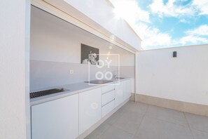 A modern outdoor kitchen with a sink, countertop, and cabinets. - La Llana penthouse oasis with rooftop kitchen and pool - by OYOOSTAYS (San Pedro del Pinatar)