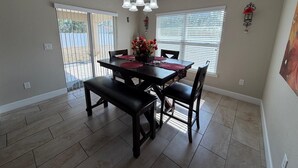A dining area with a dark wooden table, four chairs, and a chandelier. - Spacious 4-bedroom house in perfect Ocala with cool AC (Ocala)