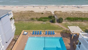 A pool area with lounge chairs and a view of the beach. - Sea Colony #35B - Sunrise Balcony +  Community Pool (Carolina Beach)