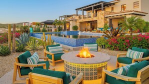 An outdoor patio with a fire pit, lounge chairs, and a pool. - Modern Diamante Golf Villa w/ Heated Pool, Hot Tub, Golf Cart & Ocean Views (Cabo San Lucas)