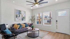 A modern living room with a sofa, armchair, and round coffee table. - Minutes to Downtown: Spacious 4br/3ba Historic Gem (San Antonio)