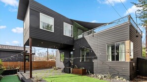 A modern two-story house with a flat roof, large windows, and a small deck. - Gladeview Dr (Austin)