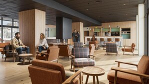 Een ruime lobby met moderne zitplaatsen, een bar en grote ramen met uitzicht.