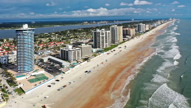 A coastal cityscape with a long sandy beach, high-rise buildings, and a clear view of the ocean. - Feel the Sea Breeze, Stylish 2 BR Condo on the Beach W/ Pool (Daytona Beach)