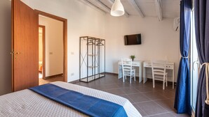 Un dormitorio con cama, escritorio y silla.