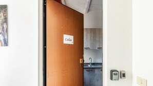 Una cocina con un lavamanos, armarios y una balanza digital en la pared.