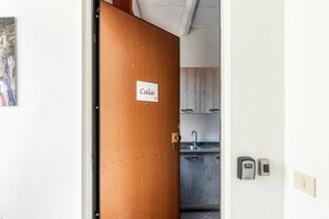 Eine Küche mit Spüle, Schränken und einer digitalen Waage an der Wand.